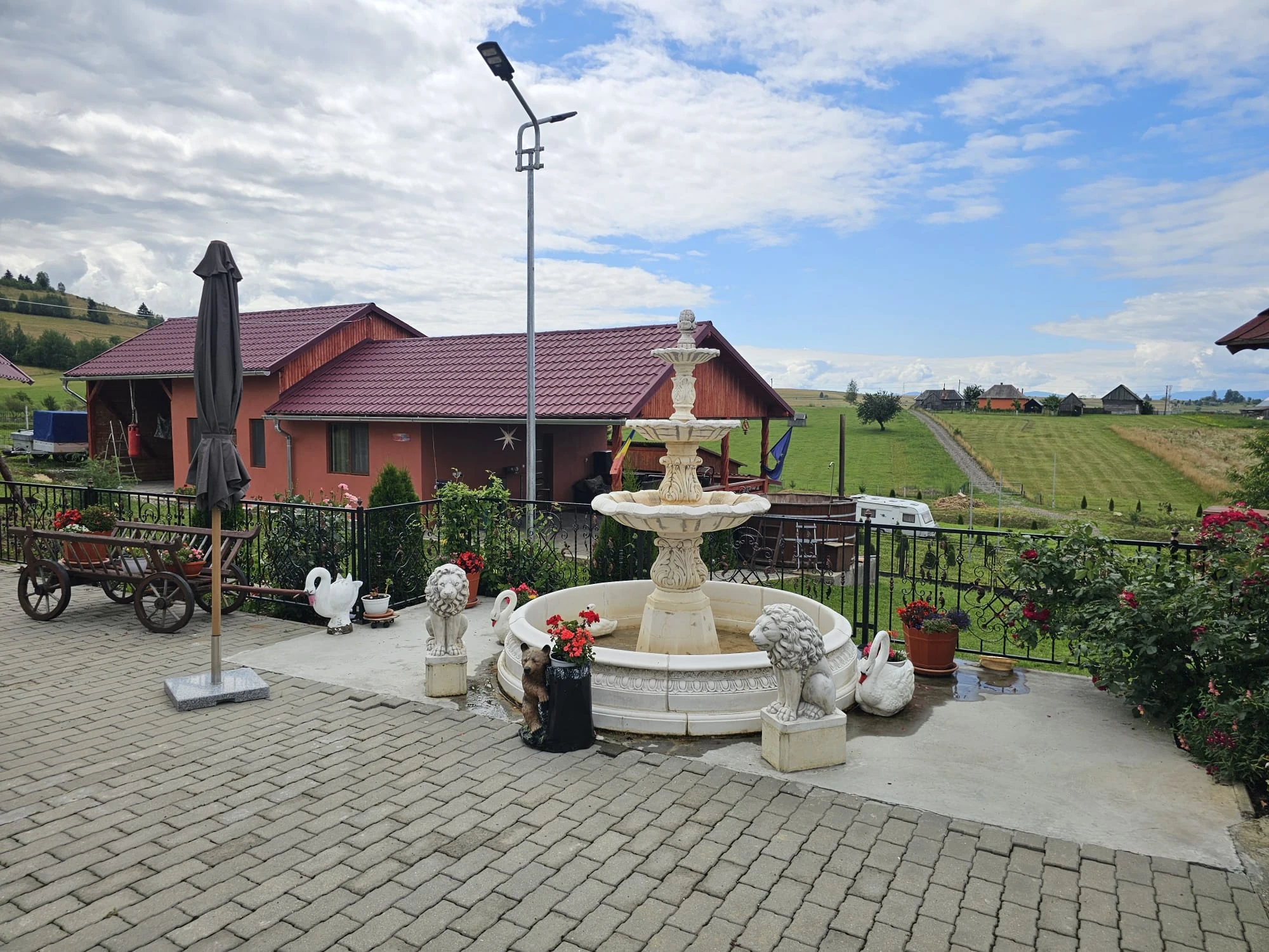 Curtea Pensiunii Vilcan cu fântână decorativă