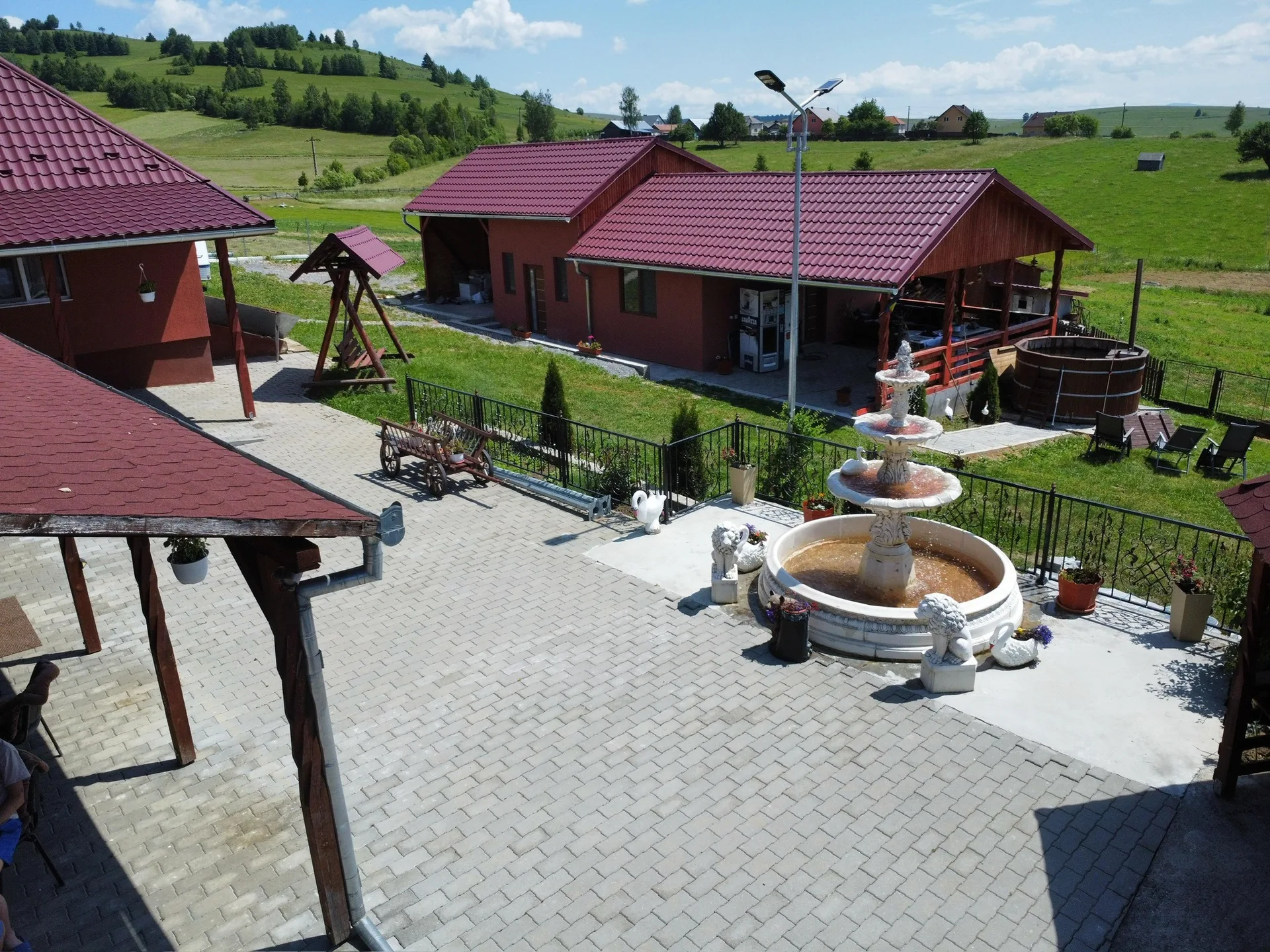 Curtea Pensiunii Vilcan cu fântână și spațiu verde